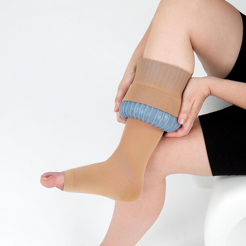 Carer assisting a patient with compression stockings using the Doff N’ Donner Sleeve.