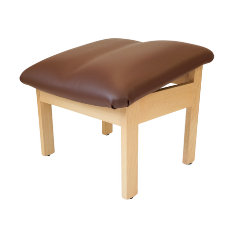 Sloping brown vinyl footstool with tapered wooden legs, designed for leg elevation and seated comfort.
