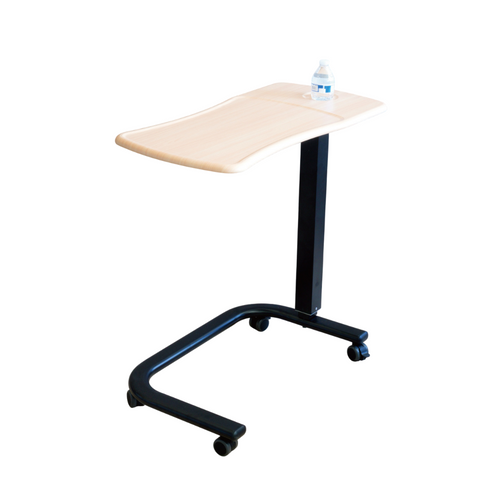 Overbed table with wood-grain finish and black steel frame, height adjustable with gas spring lift mechanism.